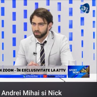 Ein Mann in einem Anzug sitzt am Tisch und spricht in eine Kamera.